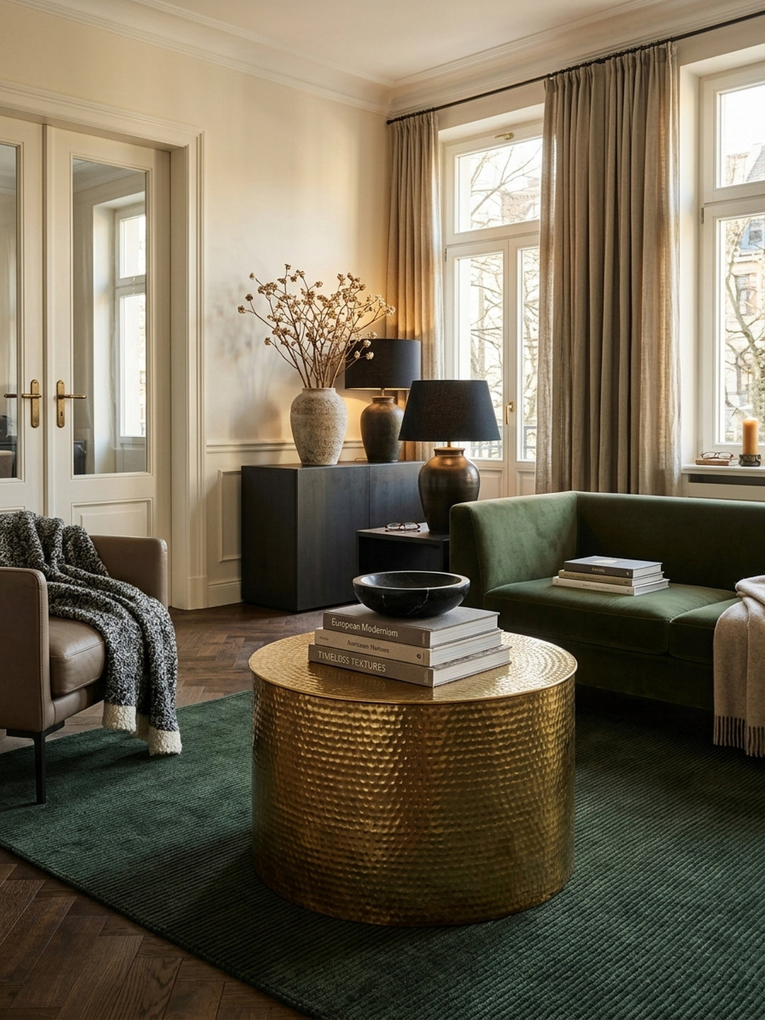 Draufsicht auf den goldenen Metall-Couchtisch im modernen Wohnbereich. Die 61 cm breite, glänzende Oberfläche mit Hammerschlag-Muster bietet viel Platz für stilvolle Raumdekoration._