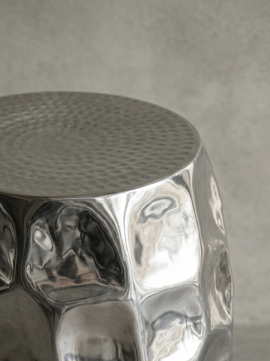 Alternativer Winkel des runden Aluminium-Tisches in Silber. Die geschlossene Form ohne sichtbare Beine verleiht dem Möbelstück einen skulpturalen Charakter._
