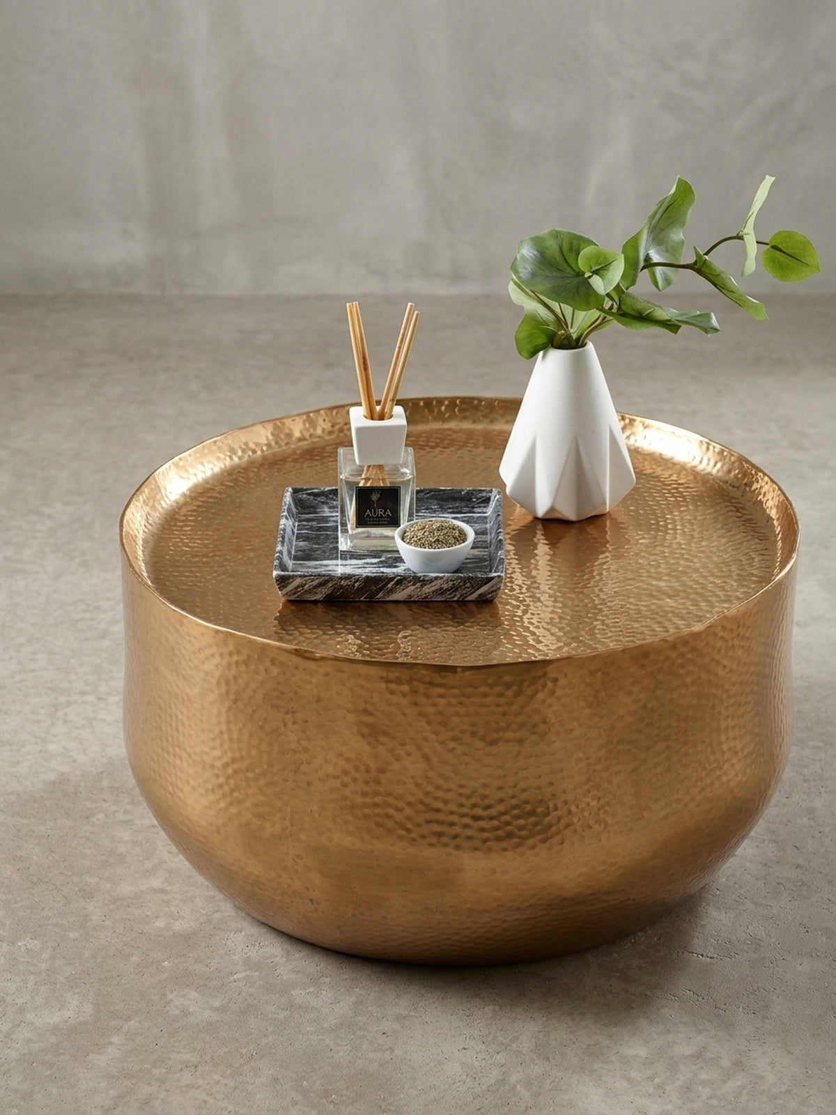 Der runde orientalische Couchtisch mit einem Durchmesser von 60 cm in einer alternativen Perspektive, die den Glanz des goldfarbenen Metalls hervorhebt._