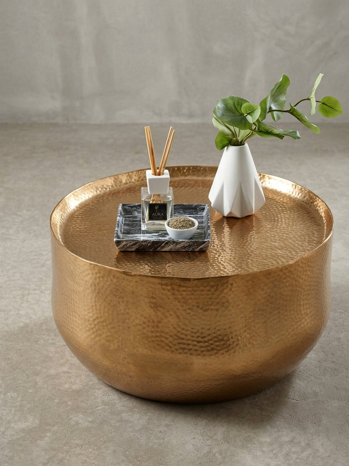 Der runde orientalische Couchtisch mit einem Durchmesser von 60 cm in einer alternativen Perspektive, die den Glanz des goldfarbenen Metalls hervorhebt._