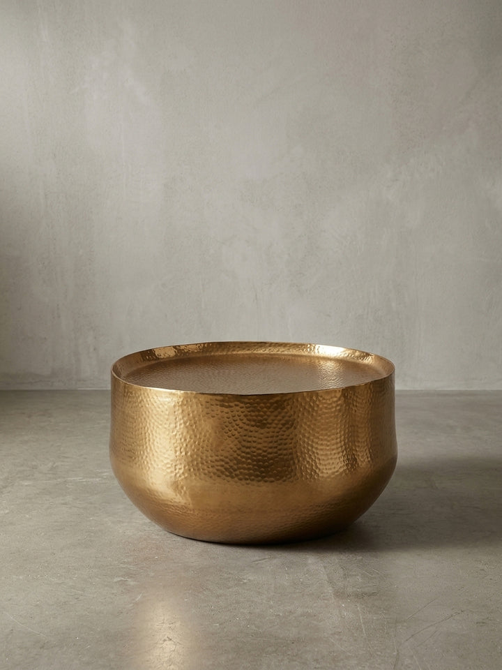 Gesamtüberblick des runden Metall-Couchtischs in Gold, der die harmonische Verbindung von orientalischem Design und moderner Eleganz darstellt._