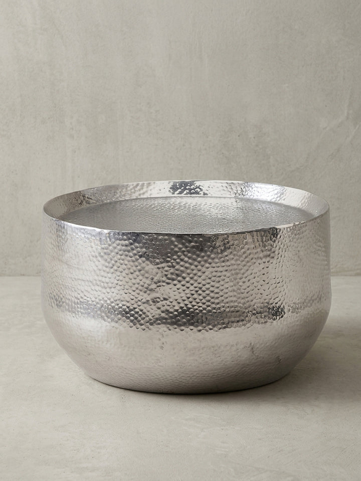 Der runde Wohnzimmertisch aus silberfarben lackiertem Aluminium in der Gesamtansicht, ein Schmuckstück im Hammerschlag-Design für jedes Interieur._