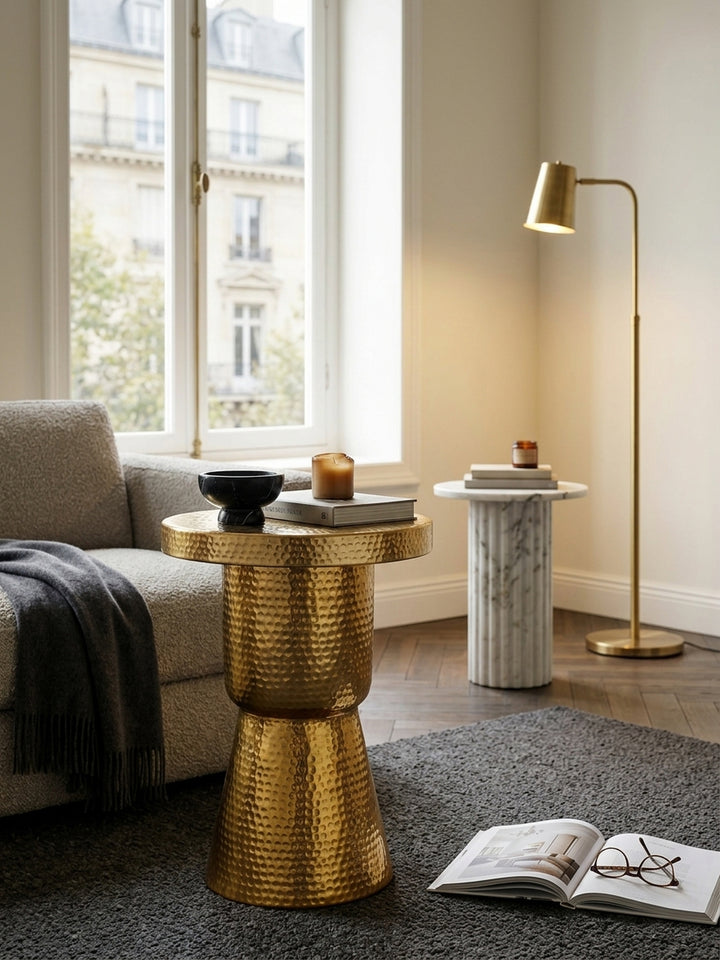 Nahaufnahme der edlen Hammerschlag-Struktur des goldenen Beistelltischs. Das handgefertigte Aluminium reflektiert das Licht und zeigt die hochwertige Verarbeitung des Metalltisches._