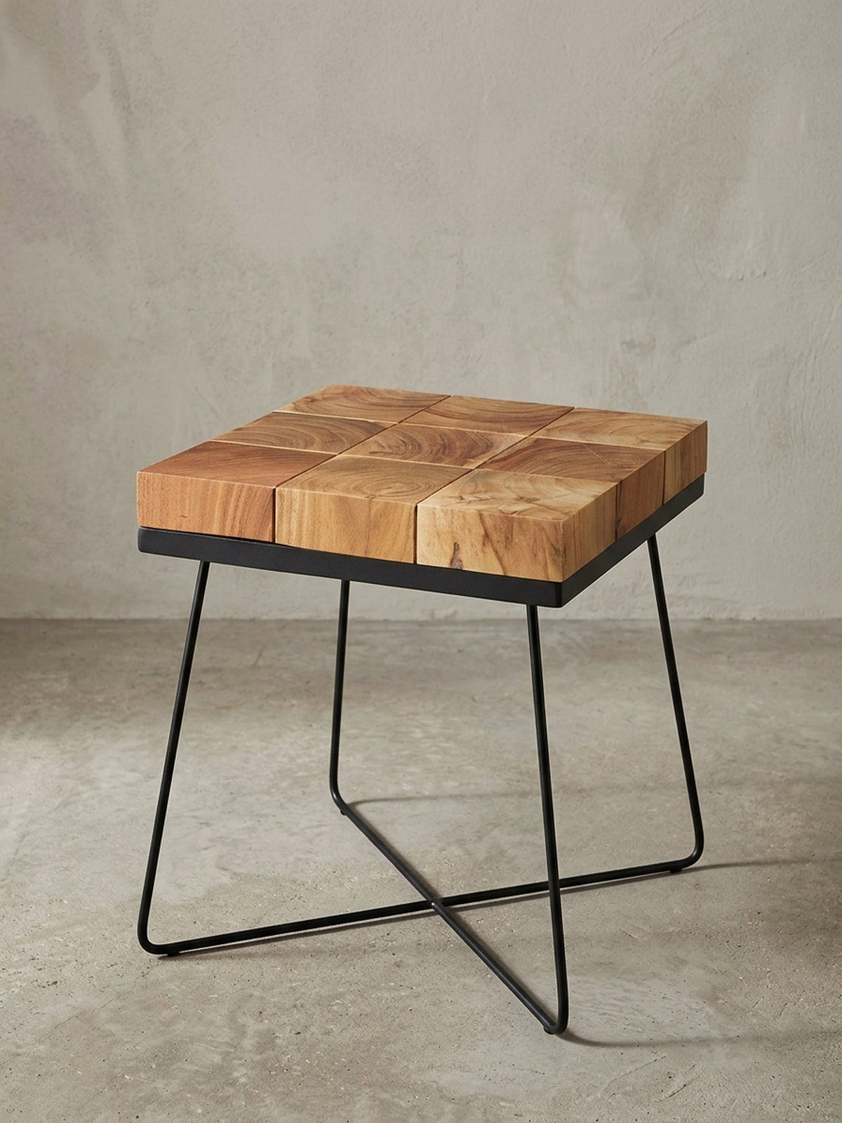 Quadratischer Anstelltisch in Frontalansicht mit einer markanten Massivholzplatte aus brauner Akazie und einem filigranen, mattschwarzen Metallkreuzgestell im Retro-Design.