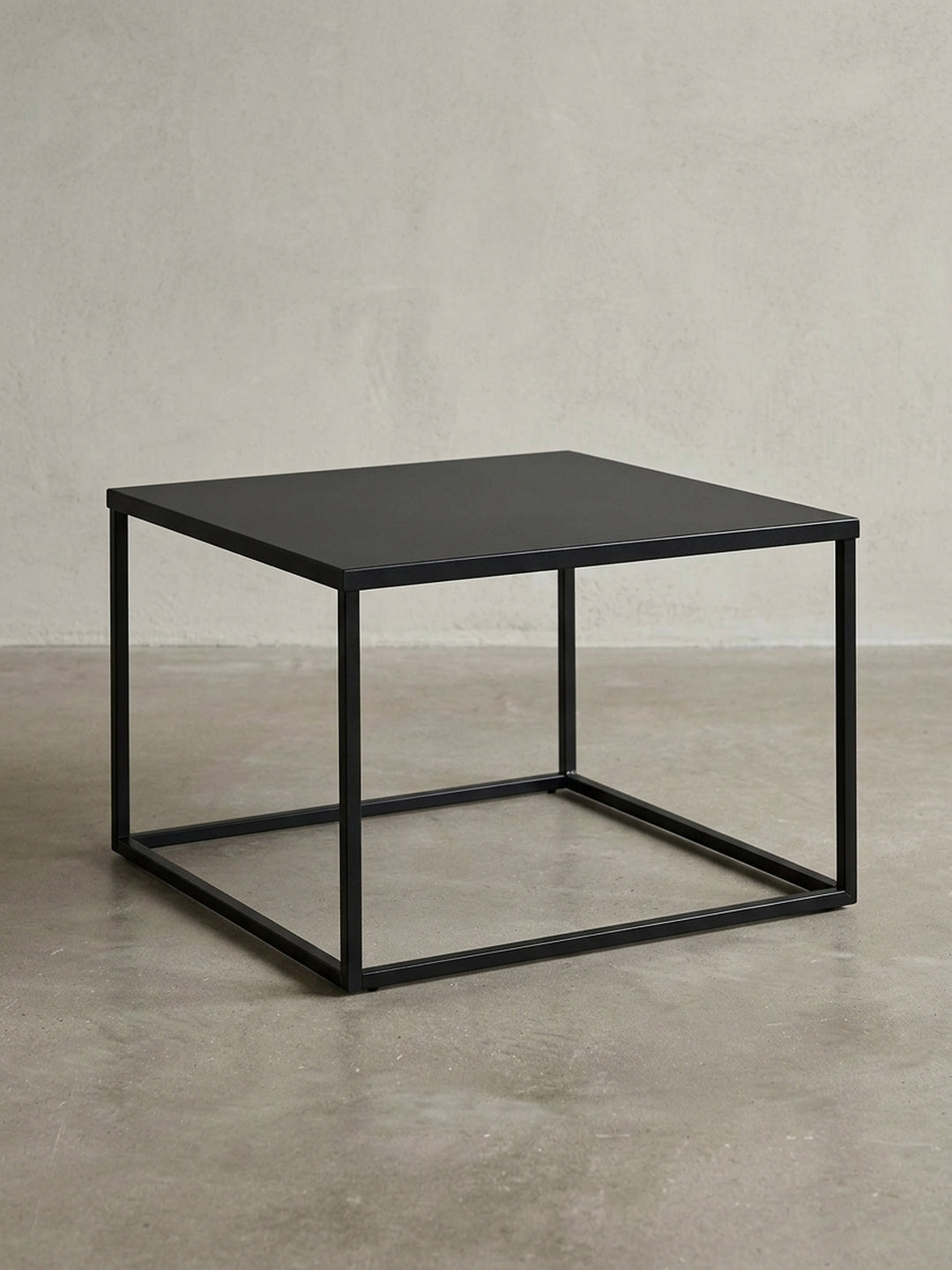 Frontansicht des quadratischen Couchtischs aus schwarzem Stahl, der seine minimalistische, kubische Silhouette auf weißem Hintergrund zeigt._