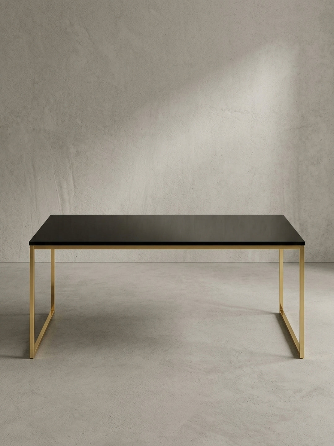 Schräger Blick auf den Design Wohnzimmertisch in Schwarz und Gold, der die schlanke Silhouette und das offene Rahmendesign aus lackiertem Metall zeigt._
