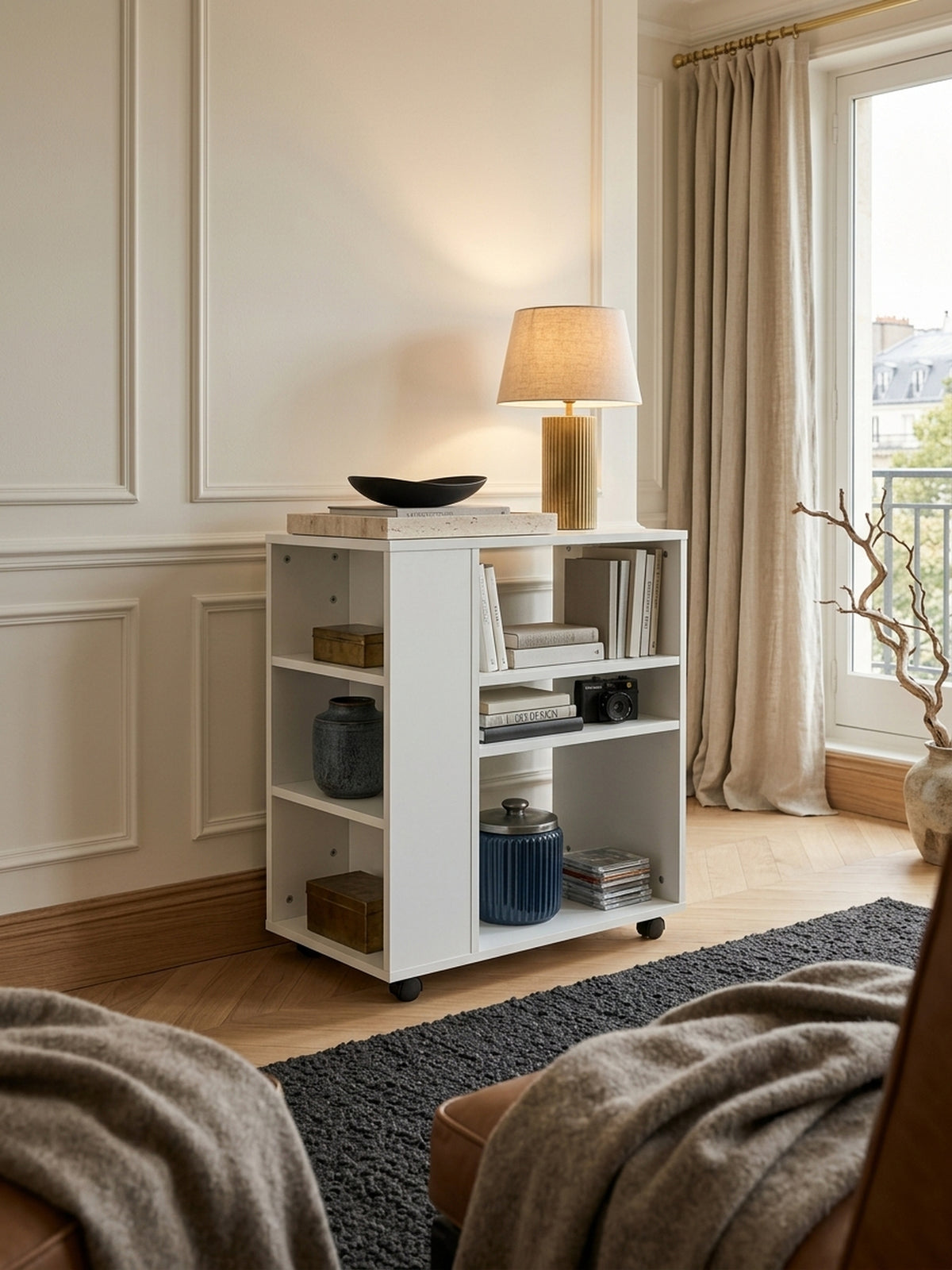 Schmales Bücherregal in reinem Weiß auf Rollen, elegant integriert in ein luxuriöses Home Office mit Eichenparkett. Der 60x75x35 cm große Rollwagen bietet flexiblen Stauraum.