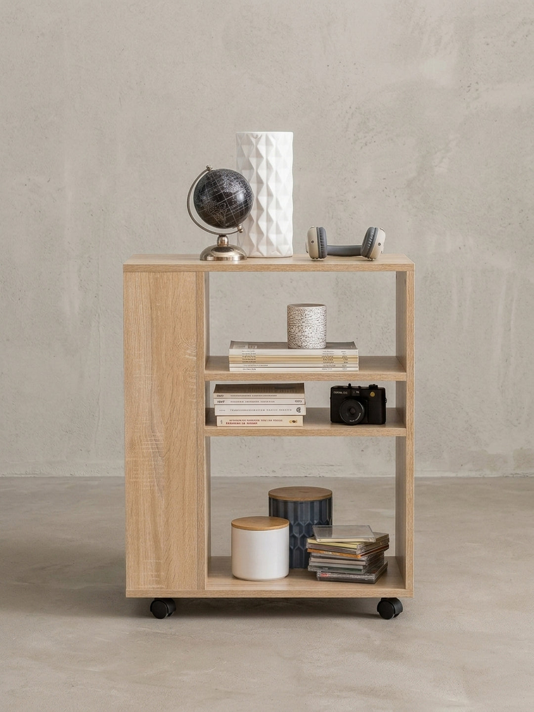 Alternative Perspektive des kompakten Holzregals. Die untere Ablage bietet großzügigen Stauraum für Ordner, während die Lenkrollen den schmalen Regalwagen äußerst mobil im Raum machen._