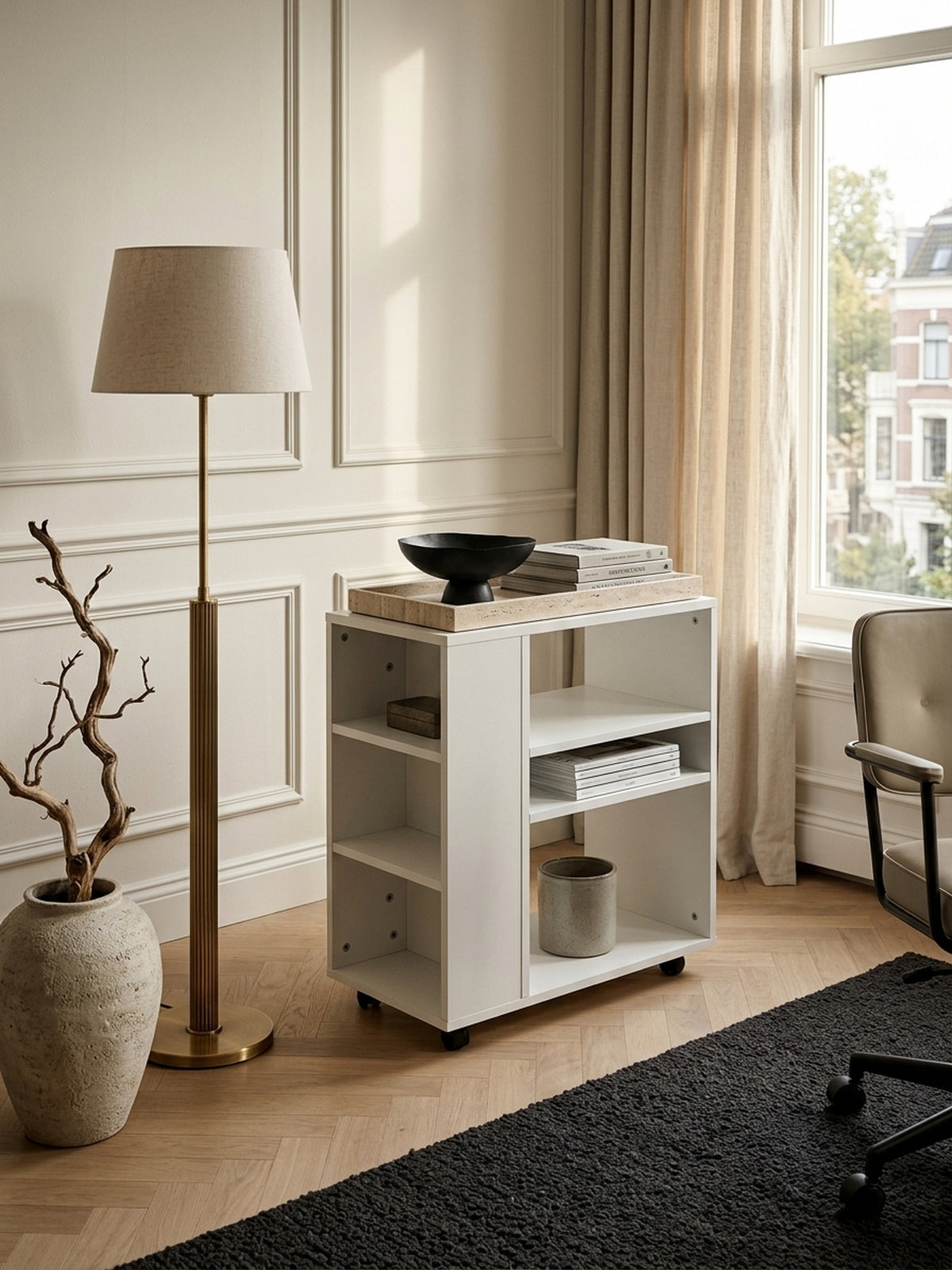 Draufsicht auf den weißen Regalwagen im modernen Arbeitszimmer. Die asymmetrische Fächereinteilung der melaminbeschichteten Spanplatte zeigt praktische Ablageflächen für Akten._