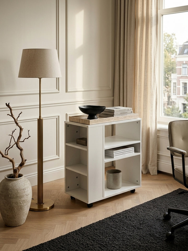 Draufsicht auf den weißen Regalwagen im modernen Arbeitszimmer. Die asymmetrische Fächereinteilung der melaminbeschichteten Spanplatte zeigt praktische Ablageflächen für Akten._