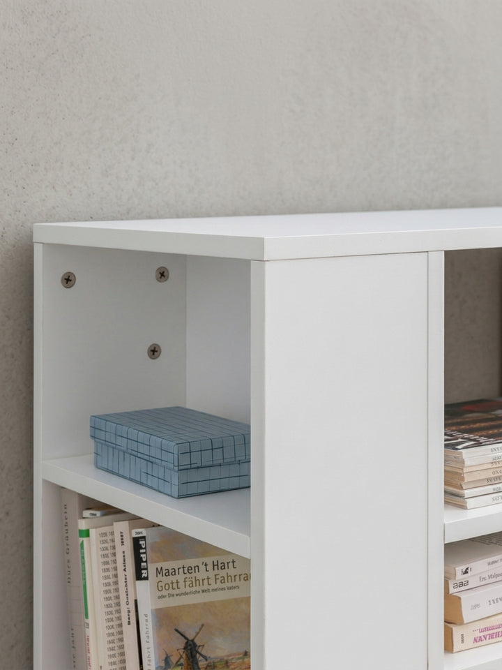 Gesamtübersicht des geometrischen Bücherregals in strahlendem Weiß. Klare Linien und der Mix aus offenen Fächern machen den Rollwagen zum perfekten Begleiter neben dem Schreibtisch._