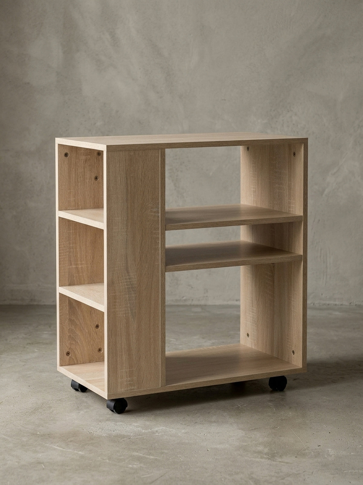 Freigestellter Rollwagen aus Holz in heller Eichenoptik von vorne. Das schmale Bücherregal (60cm breit) zeigt seine asymmetrischen Fächer und vier praktischen schwarzen Lenkrollen._