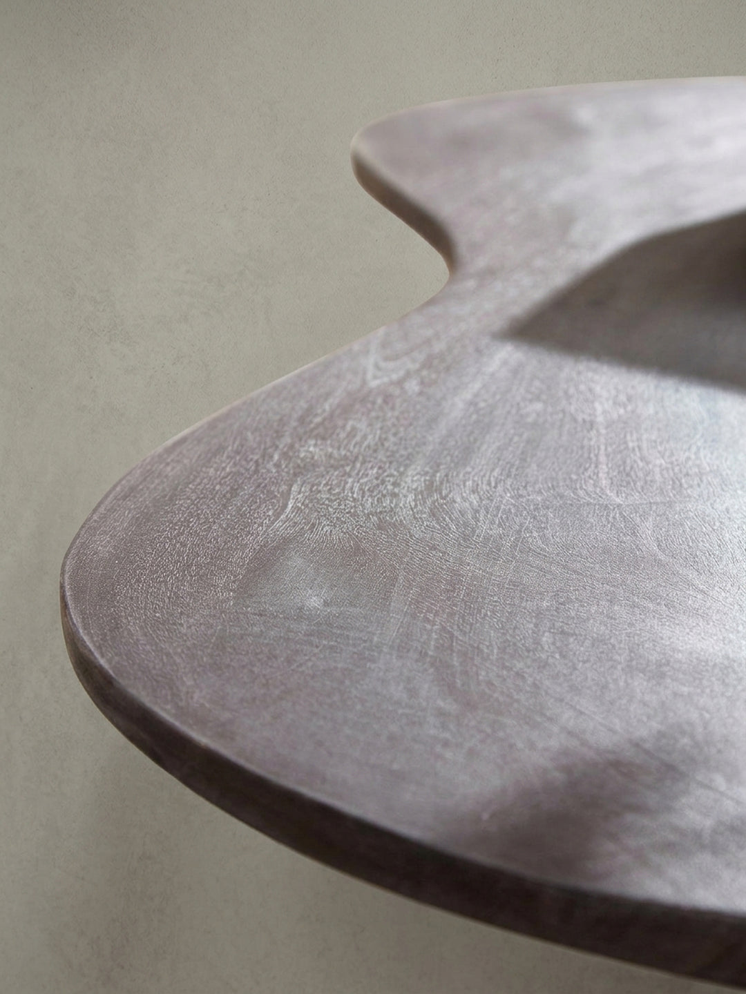 Nahaufnahme des Übergangs zwischen filigranem Metallbein und Tischplatte. Der klare Schutzlack schützt und betont die natürliche Holzmaserung des Massivholz Couchtisches optimal._