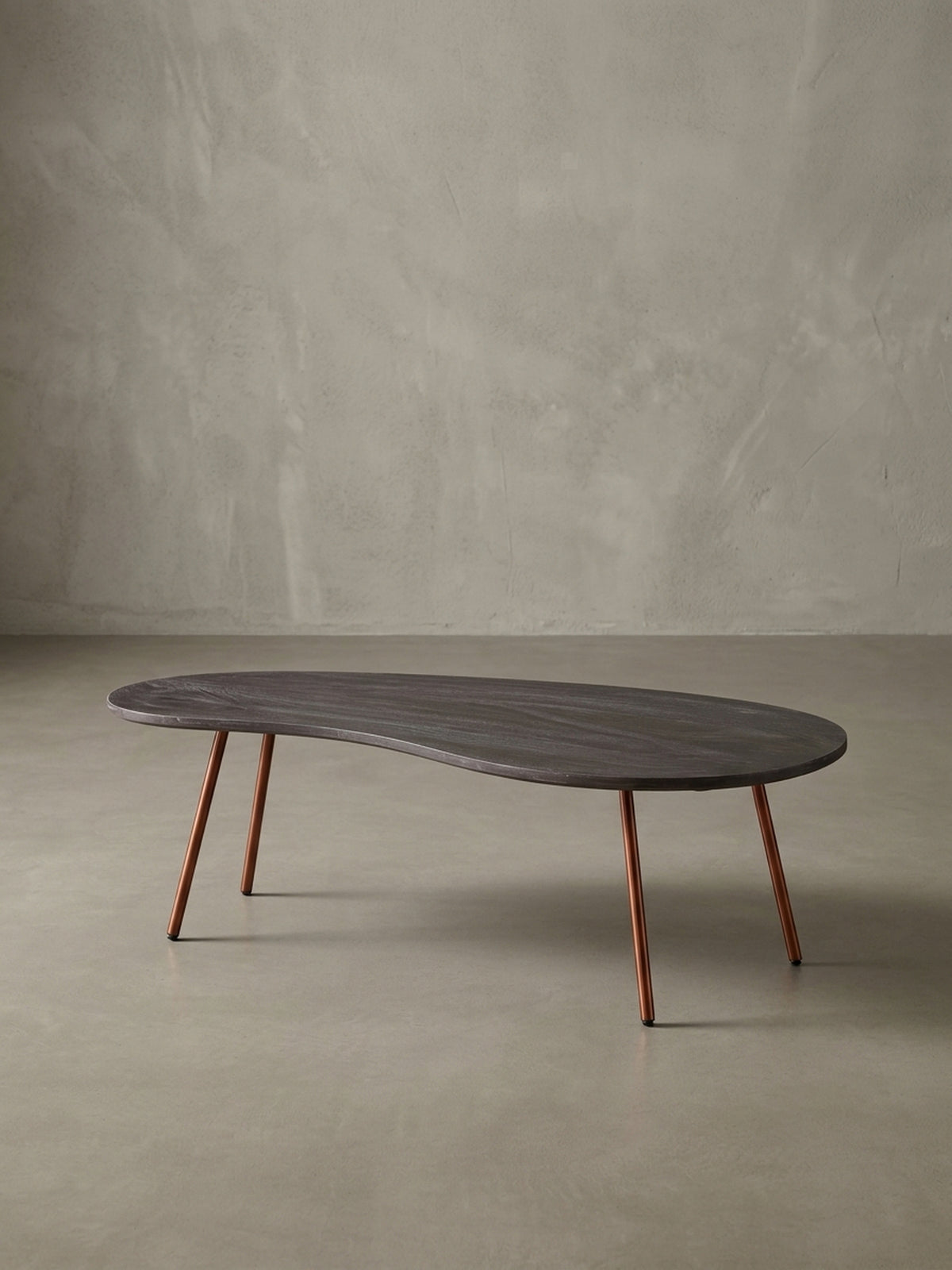 Weitere Perspektive des organischen Wohnzimmertisches im 50er Jahre Design. Dunkles Massivholz und elegantes kupferfarbenes Metall verschmelzen zu einem hochwertigen Möbelstück._