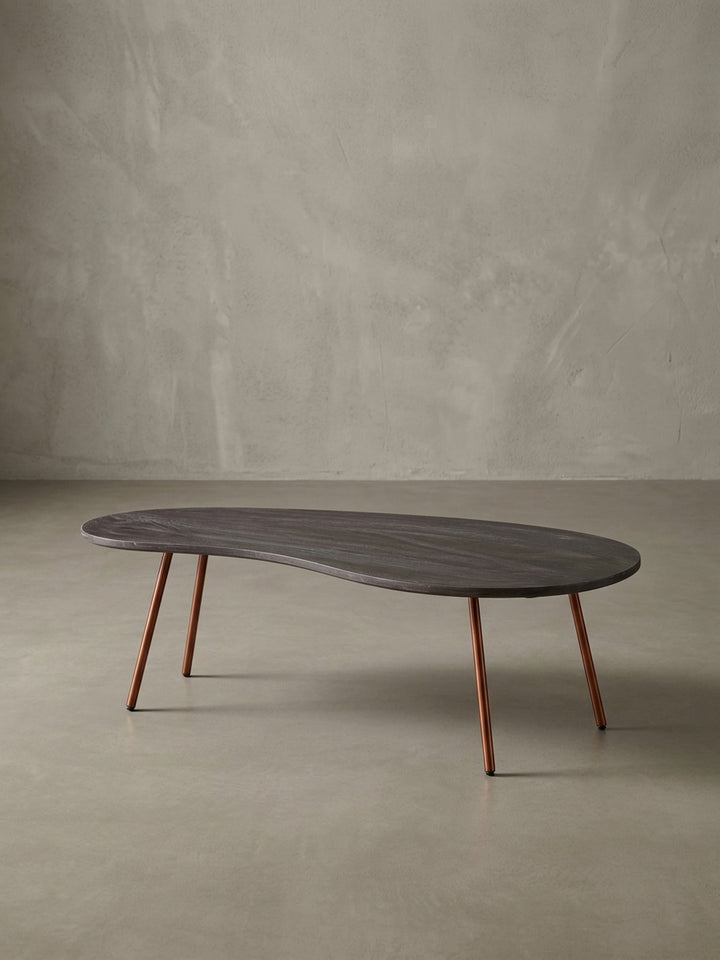 Weitere Perspektive des organischen Wohnzimmertisches im 50er Jahre Design. Dunkles Massivholz und elegantes kupferfarbenes Metall verschmelzen zu einem hochwertigen Möbelstück._