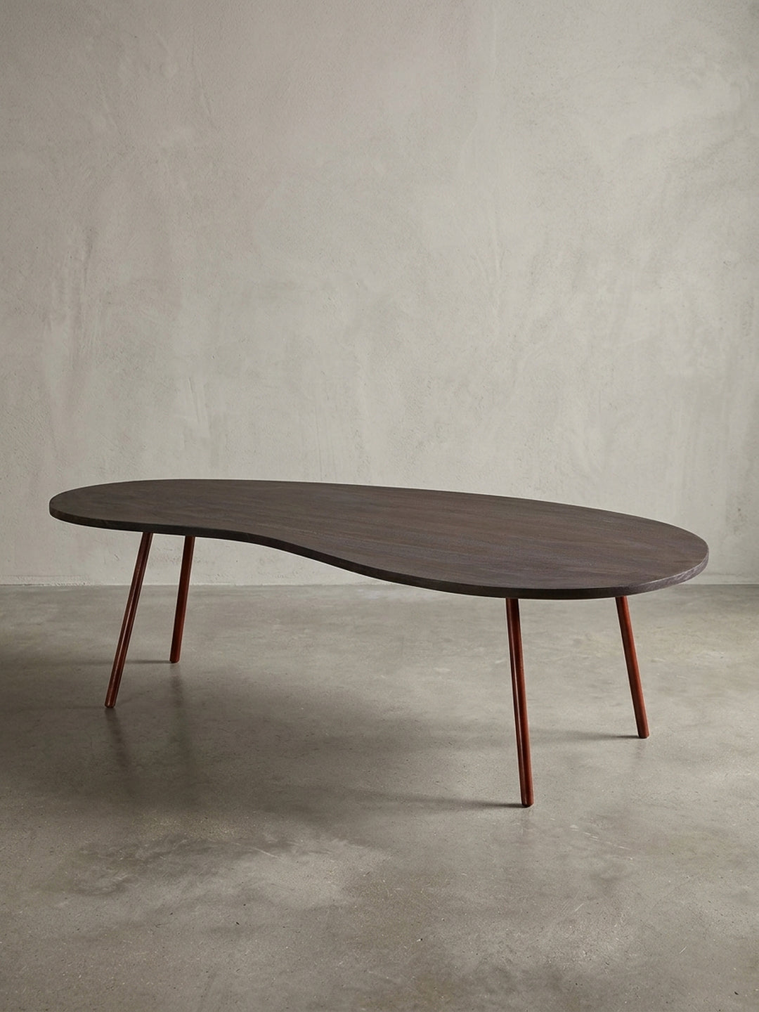 Gesamtansicht des extravaganten Nierentisches auf weißem Hintergrund. Der 122x63cm große Couchtisch verbindet Retro-Charme mit hochwertigen Materialien wie massivem Akazienholz._