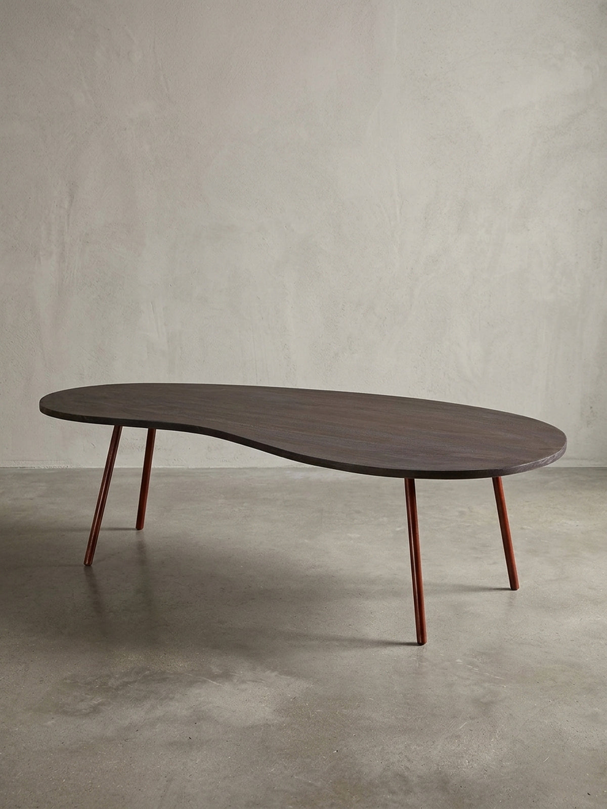 Gesamtansicht des extravaganten Nierentisches auf weißem Hintergrund. Der 122x63cm große Couchtisch verbindet Retro-Charme mit hochwertigen Materialien wie massivem Akazienholz.