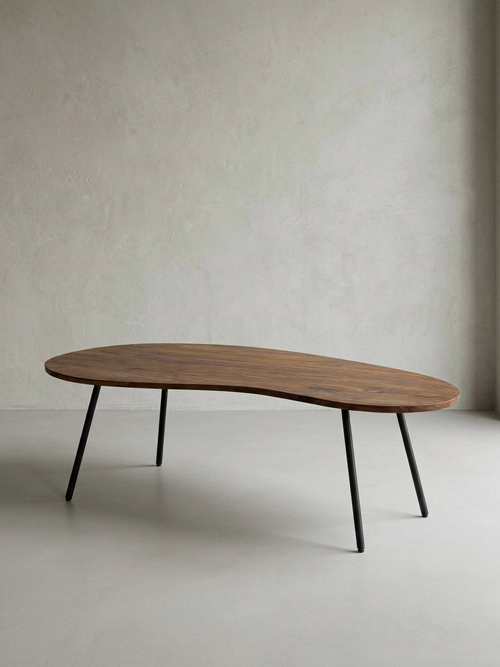 Nierentisch aus Sheesham Massivholz freigestellt vor weißem Hintergrund. Frontale Ansicht des 122x63 cm großen Couchtischs mit markanter organischer Form und dunklen Metallbeinen._