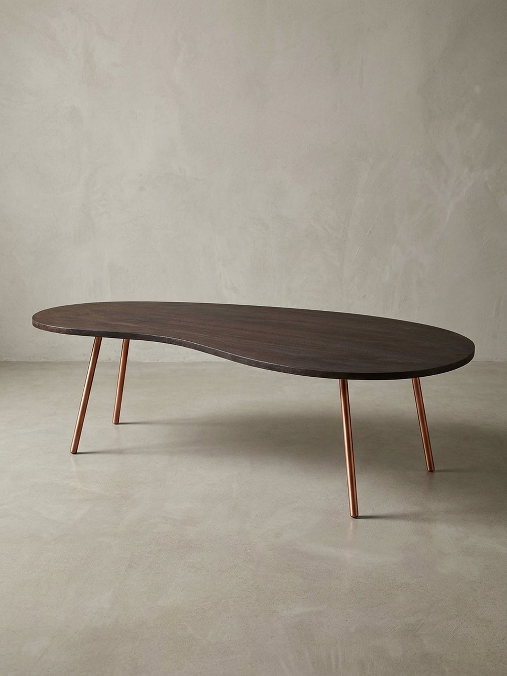 Freigestellter Design Couchtisch Nierentisch in Dunkelbraun mit schräg gestellten kupferfarbenen Metallbeinen. Mid-Century Stil für moderne Wohnzimmer und stilvolle Einrichtungen._