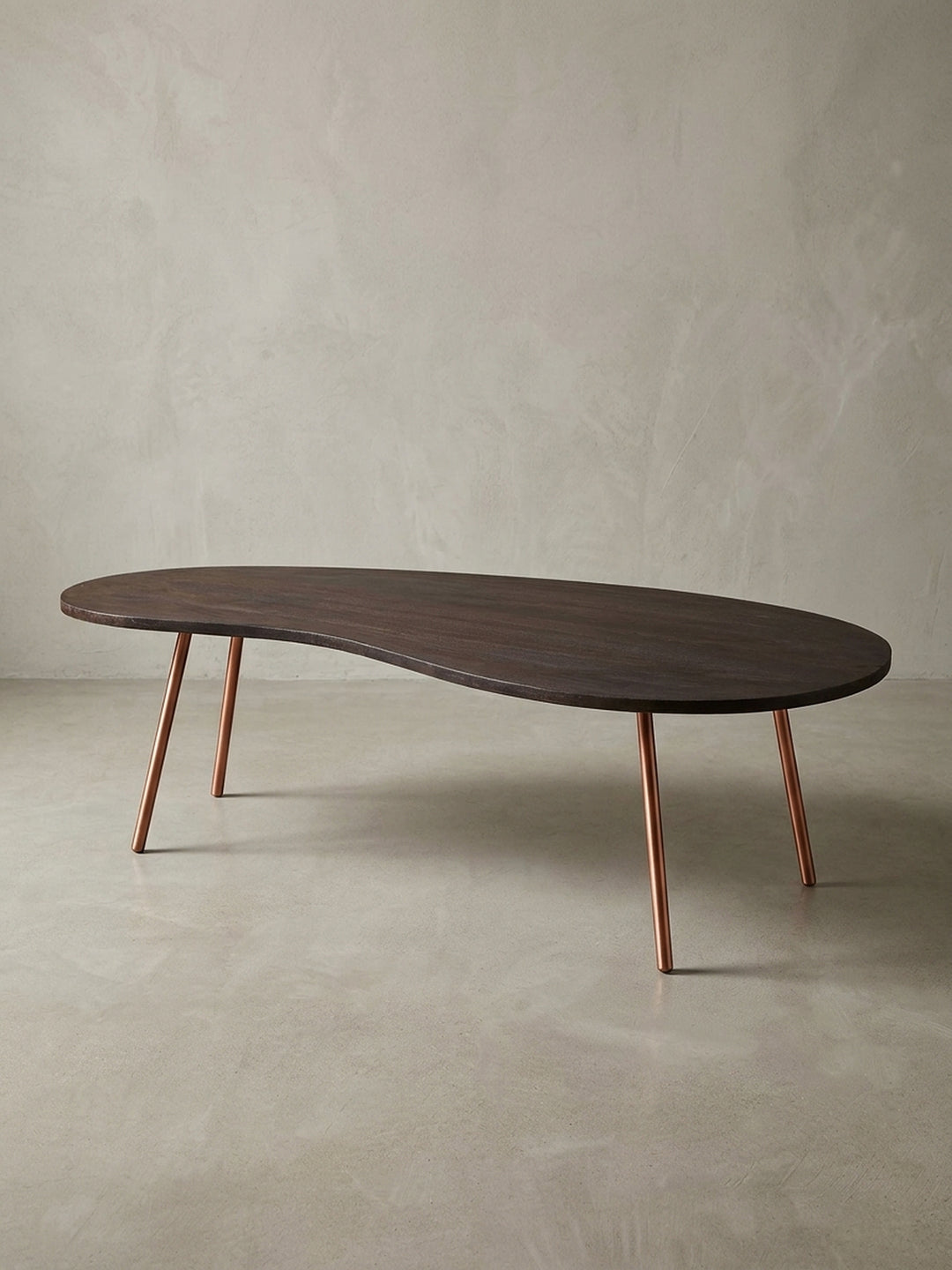 Freigestellter Design Couchtisch Nierentisch in Dunkelbraun mit schräg gestellten kupferfarbenen Metallbeinen. Mid-Century Stil für moderne Wohnzimmer und stilvolle Einrichtungen._