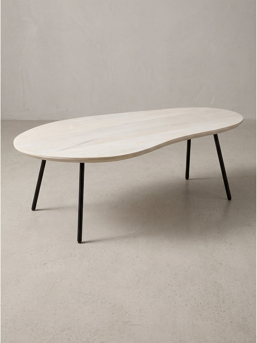 Freigestellte Frontalansicht des 122 cm breiten Nieren-Couchtisches, die den eleganten Kontrast zwischen der hellen Massivholzplatte und den filigranen schwarzen Metallbeinen zeigt_