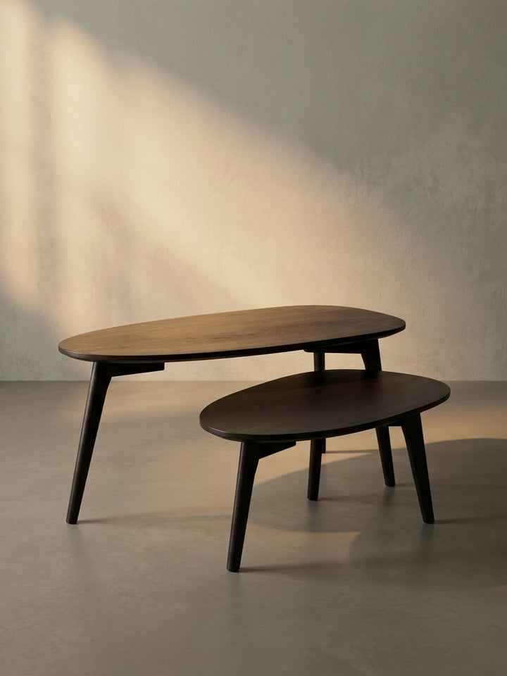 Der Design-Couchtisch in Nierenform aus der Dreiviertelperspektive, die schräg gestellten, konischen Holzbeine im Mid-Century-Stil betonend._