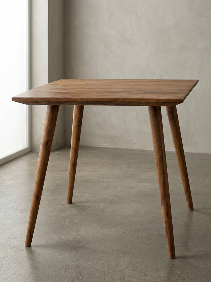 Esstisch aus warmem Sheesham-Massivholz mit markanter Maserung auf neutralem Betonhintergrund Frontalansicht 80x80x76 cm_