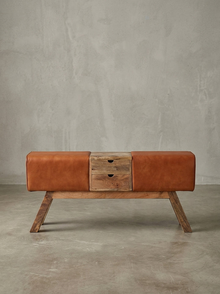 Seitenansicht der Leder-Sitzbank, die ihre schlanke Silhouette von 30 cm Tiefe und die charakteristische Form des Turnbocks mit Massivholz-Gestell hervorhebt._