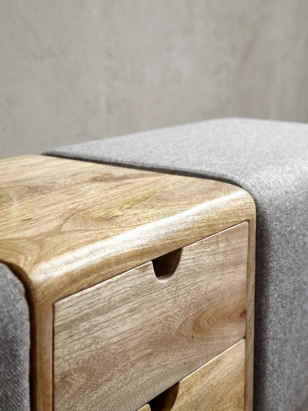 Gesamtansicht der Turnhocker Bank als Kombination aus Sitzgelegenheit und Stauraum, der Kontrast zwischen grauem Stoff und warmem Holz wirkt modern._