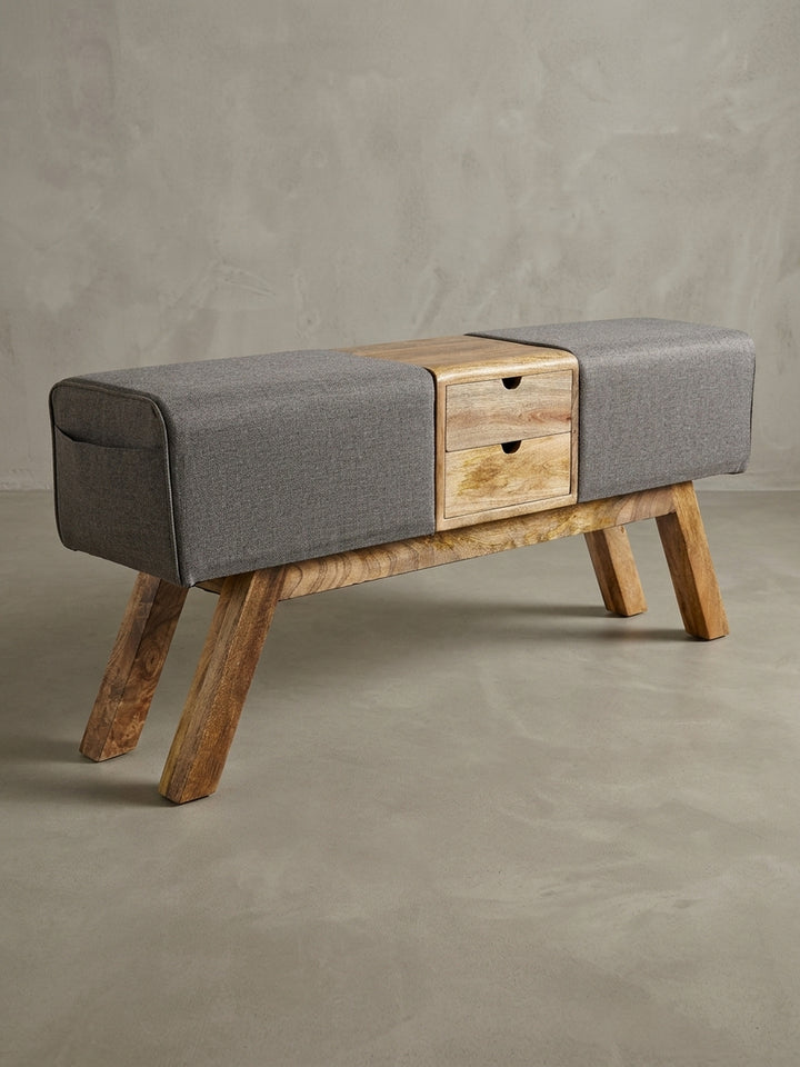 Sitzbank im Turnbock-Look in schräger 3/4-Ansicht, die Tiefe des Holzkorpus und die stabilen, abgewinkelten Beine aus Mangoholz werden sichtbar._