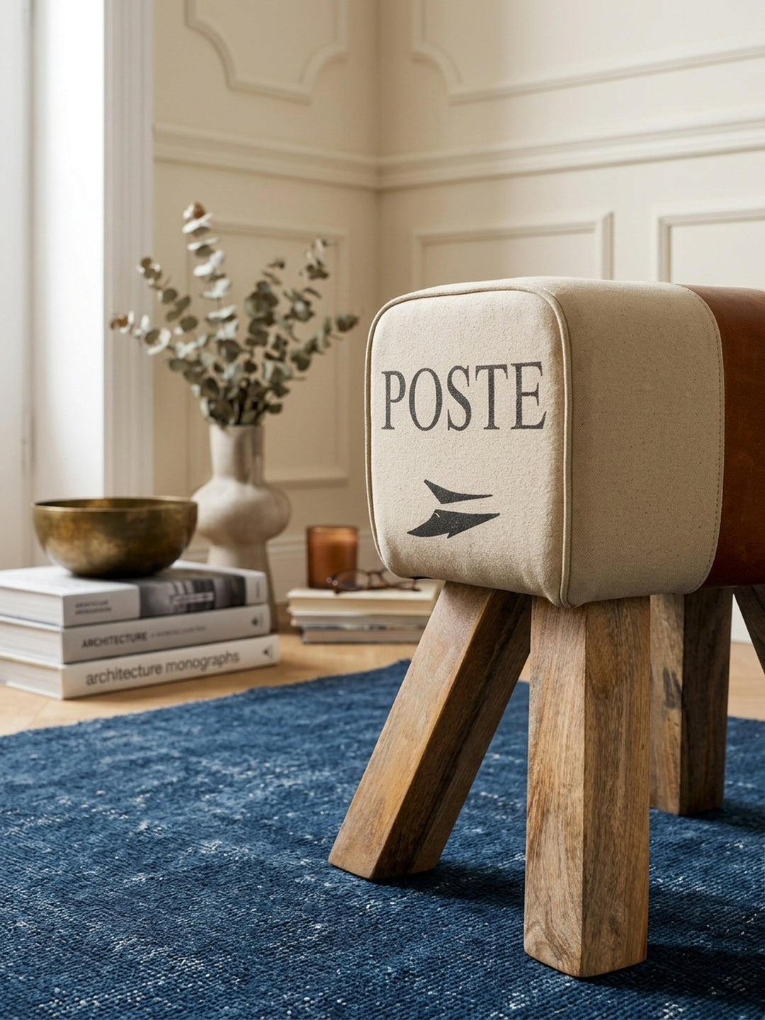 Nahaufnahme der Materialkombination: Robustes beiges Baumwollgewebe trifft auf weiches, echtes Leder, ergänzt durch präzise Nähte am 40x30 cm großen, luxuriösen Fußhocker._