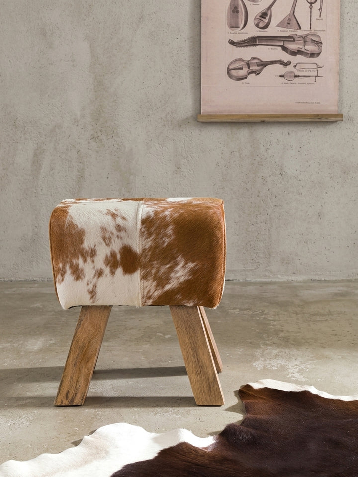 Dieser kleine Polsterhocker vereint kultiges Design mit natürlichen Materialien und dient als bequeme Sitzgelegenheit oder als skulpturaler Blickfang im Raum._