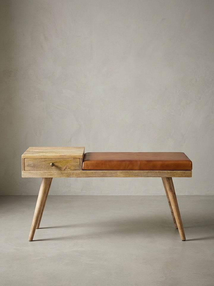 Freistehende Sitzbank aus Massivholz und Echtleder frontal fotografiert. Die 100 cm breite Flurbank mit asymmetrischer Schublade zeigt charakteristisches Mid-Century Design._