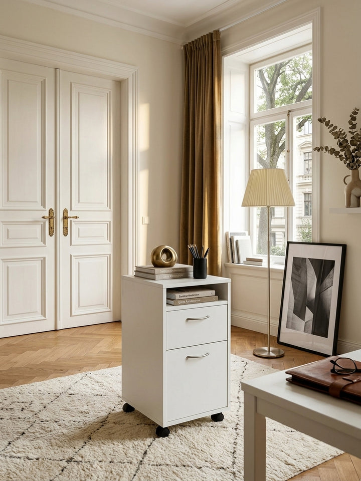 Eleganter weißer Rollcontainer 33x63x38 cm im luxuriösen Home Office. Der moderne Schreibtisch-Unterschrank mit Rollen steht auf edlem Fischgrätparkett neben einem Eichenschreibtisch._