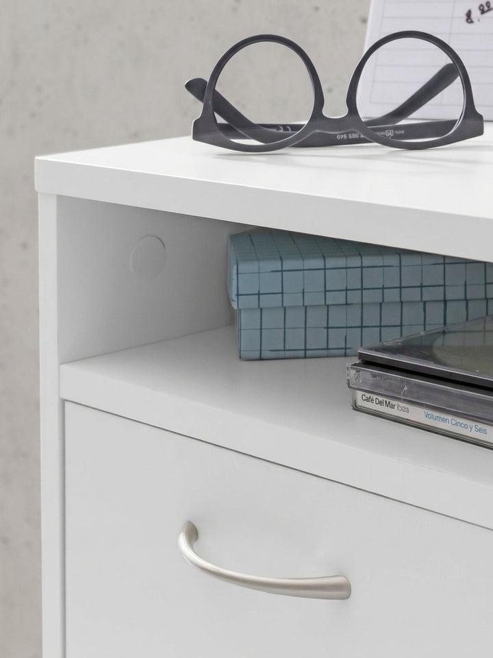 Weißer Rollcontainer mit geöffneter Schublade und Tür zeigt den Stauraum für Ihr Büro. Der mobile Beistellschrank aus Holz steht auf Rollen vor einer grauen Wand._