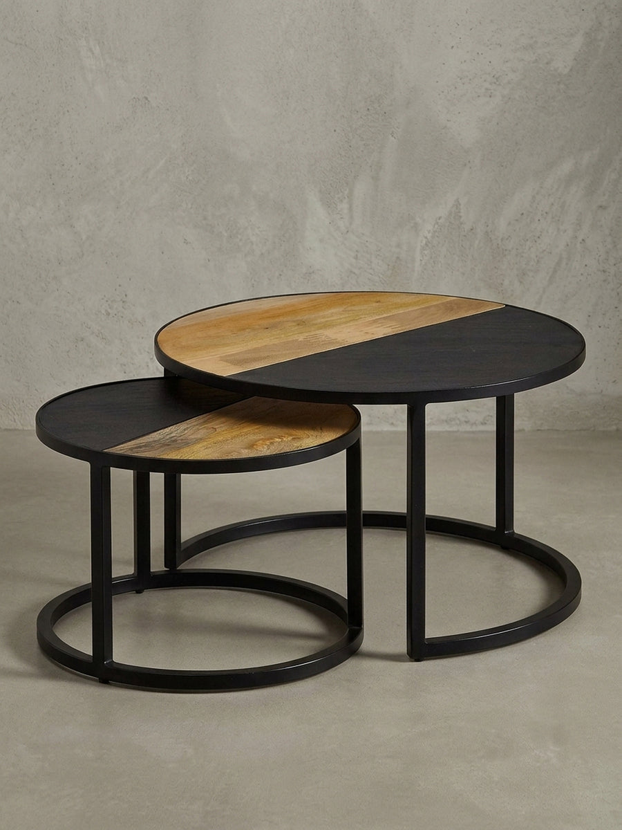 Design Beistelltisch-Set in 3/4-Ansicht, das ineinanderschiebbare Gestell aus schwarzem Metall und die runden Tischplatten betonend._