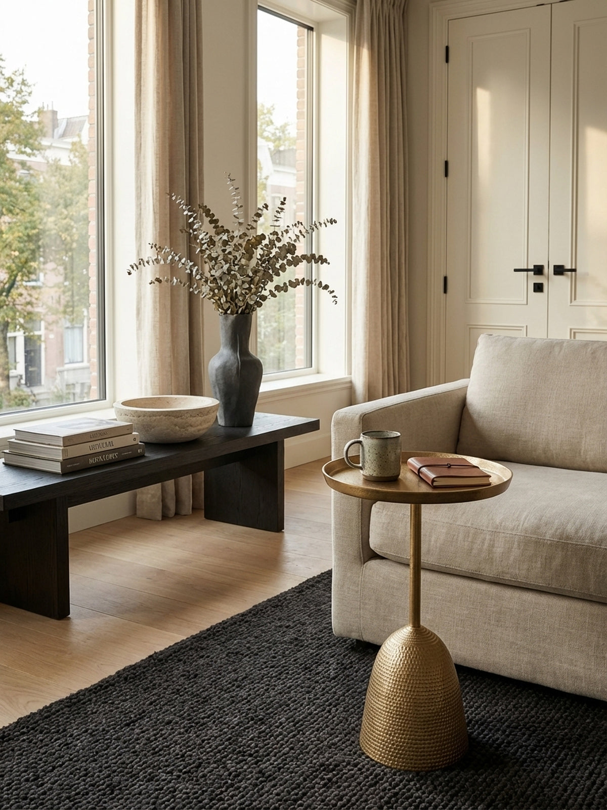 Hoher Beistelltisch in Gold, von oben fotografiert, zeigt die runde 30 cm Tablett-Platte mit einem Magazin und einer Tasse in einem hellen, einladenden Ambiente.