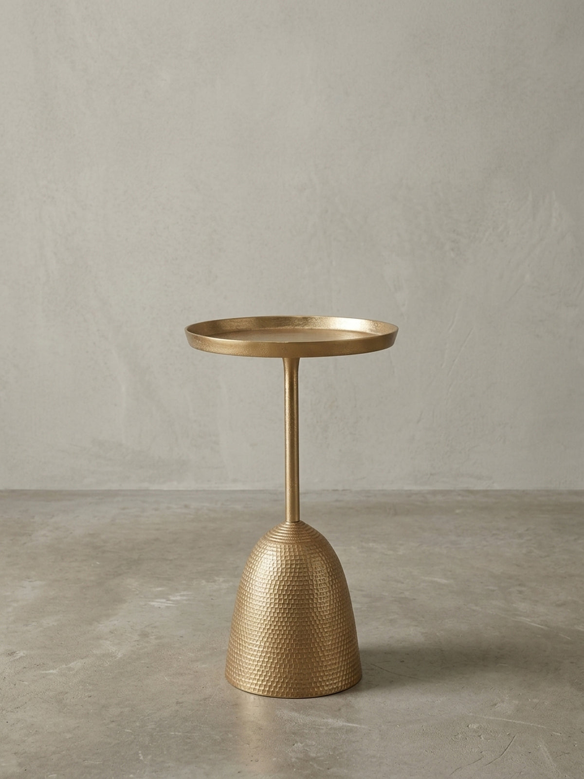 Schmaler Sofatisch in Gold, Seitenansicht, die das ausgewogene Verhältnis zwischen dem dünnen Stiel und dem massiven, glockenförmigen Fuß darstellt._