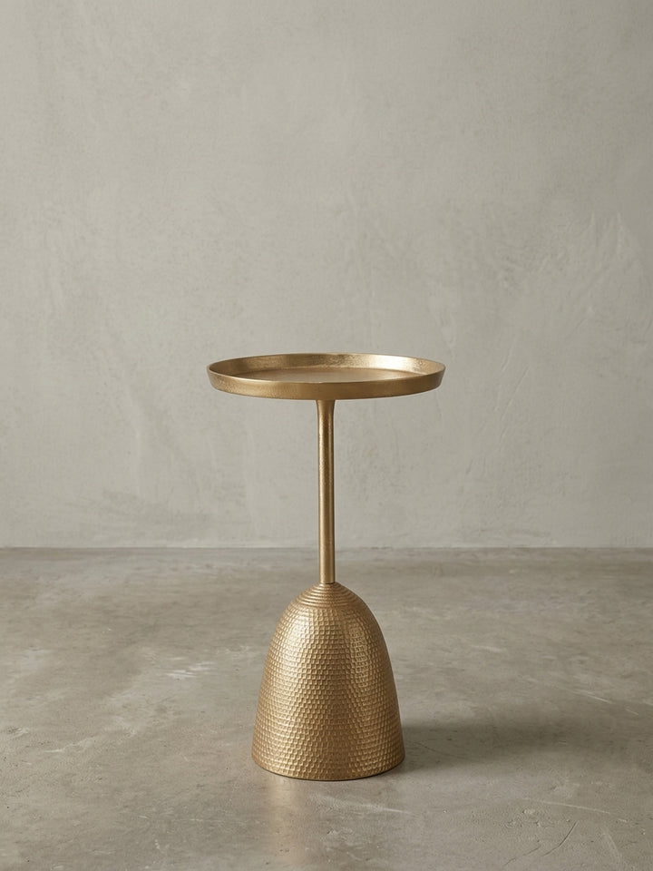 Schmaler Sofatisch in Gold, Seitenansicht, die das ausgewogene Verhältnis zwischen dem dünnen Stiel und dem massiven, glockenförmigen Fuß darstellt._