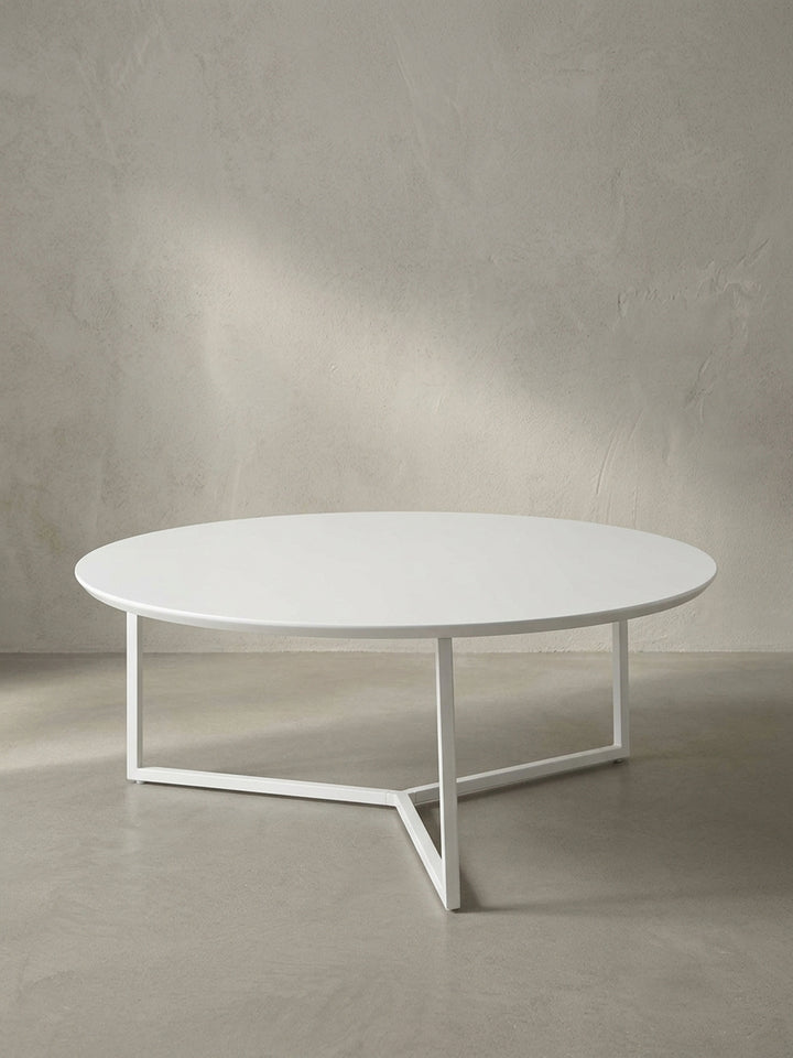 Vollansicht des runden Design-Couchtisches mit 80 cm Durchmesser aus weiß lackierter MDF-Platte und filigranem dreibeinigen Metallrahmen vor neutralem Hintergrund._