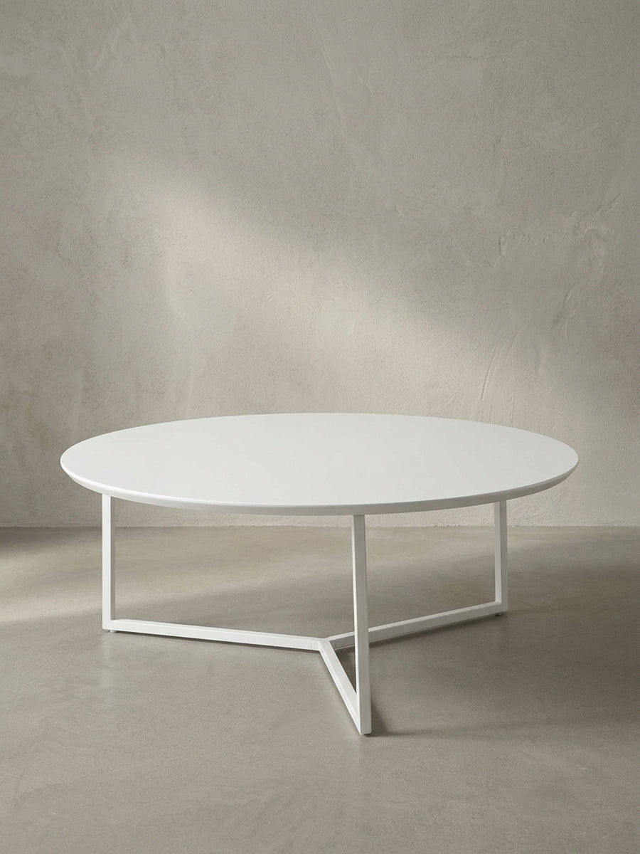 Vollansicht des runden Design-Couchtisches mit 80 cm Durchmesser aus weiß lackierter MDF-Platte und filigranem dreibeinigen Metallrahmen vor neutralem Hintergrund._