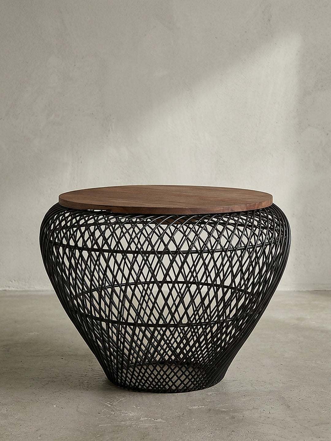 Seitenansicht des 45 cm hohen Wohnzimmertisches mit schwarzem Metallkorb und elegant nach unten verjüngtem Standfuß_