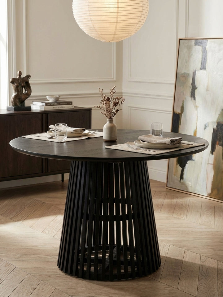 Design-Vignette mit dem schwarzen Holztisch, dekoriert mit einer schlichten Glasvase mit getrockneten Eukalyptuszweigen für ein modernes Ambiente._