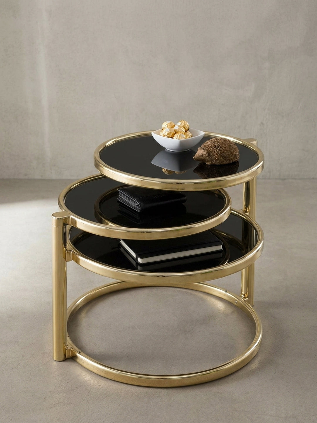 Nahaufnahme des goldfarben lackierten Stahls am Designer Couchtisch. Die sauberen Übergänge und die Befestigung der tiefschwarzen Glasplatten am modernen Beistelltisch._