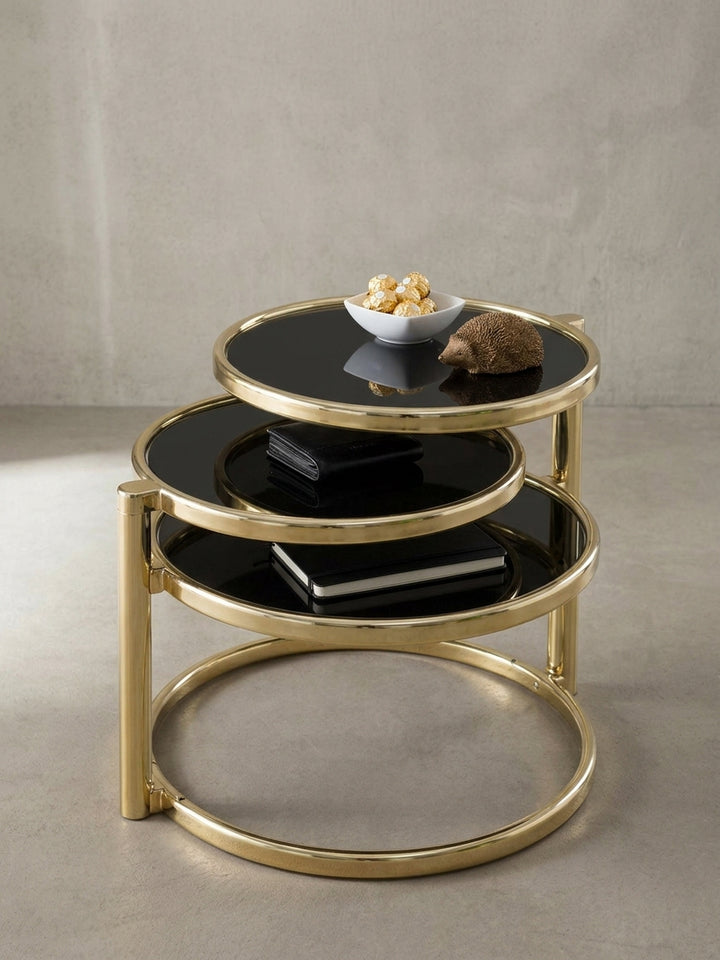 Nahaufnahme des goldfarben lackierten Stahls am Designer Couchtisch. Die sauberen Übergänge und die Befestigung der tiefschwarzen Glasplatten am modernen Beistelltisch._