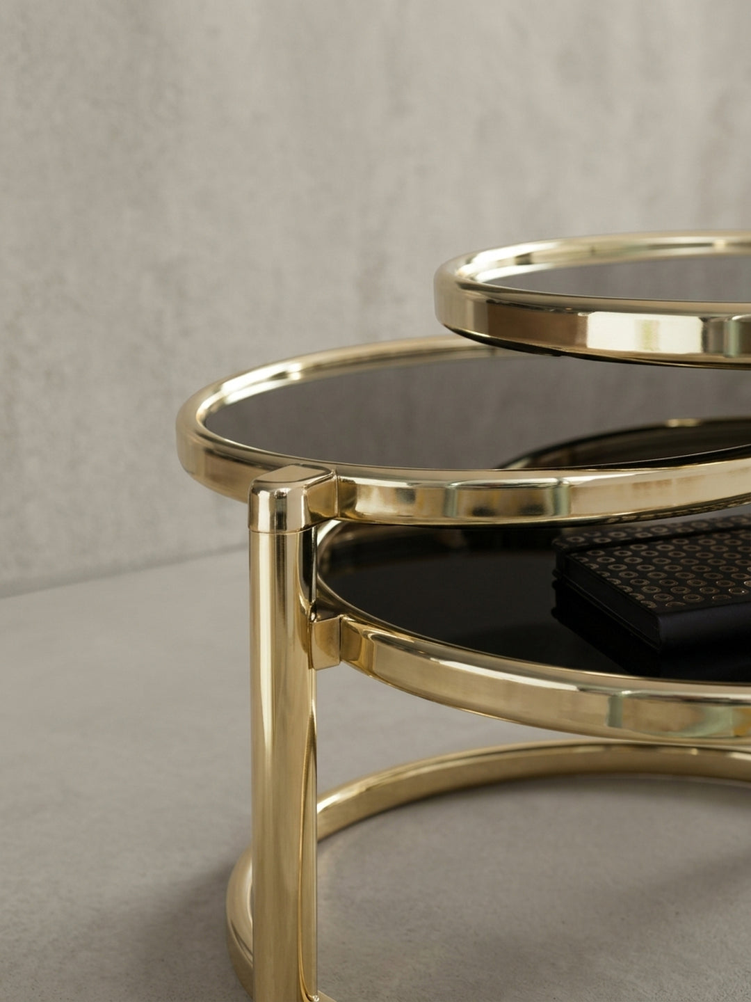 Gesamtübersicht des exklusiven Couchtisches mit 3 Ebenen. Die Kombination aus schwarzem Sicherheitsglas und goldenem Metall strahlt modernen Luxus im eleganten Wohnzimmer aus._