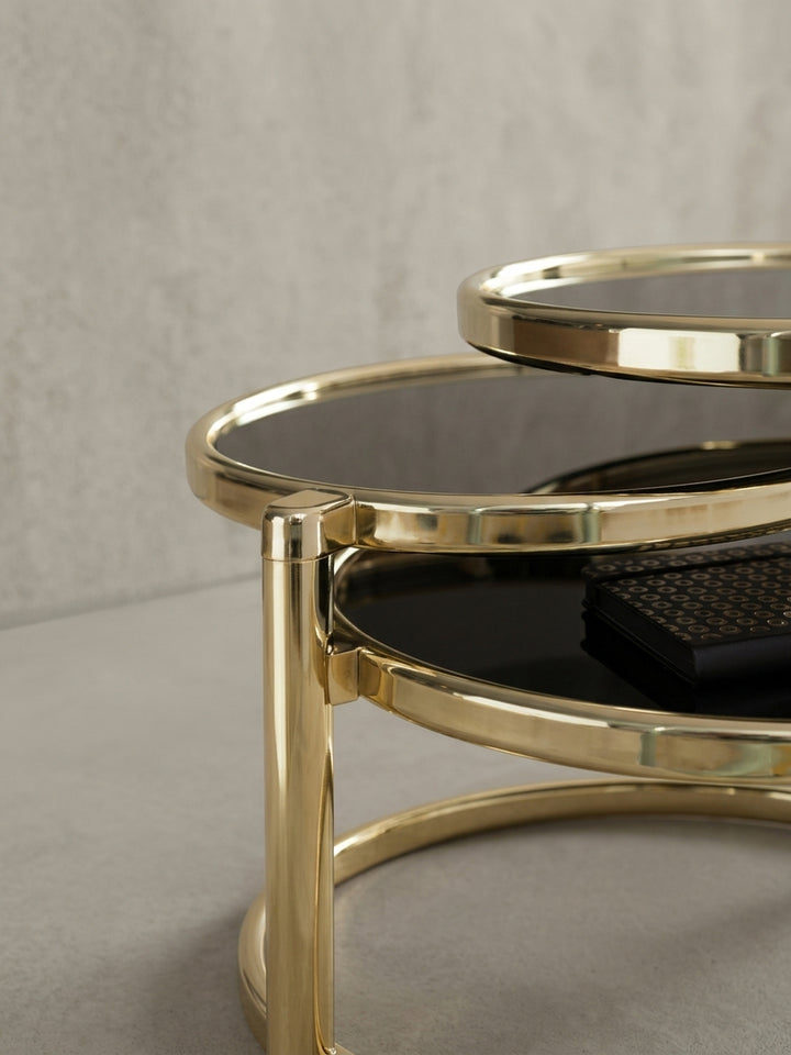 Gesamtübersicht des exklusiven Couchtisches mit 3 Ebenen. Die Kombination aus schwarzem Sicherheitsglas und goldenem Metall strahlt modernen Luxus im eleganten Wohnzimmer aus._