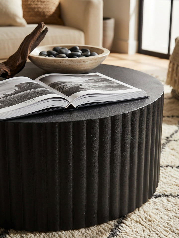 Detailaufnahme der matten, pulverbeschichteten Oberfläche und der feinen Wellen-Struktur des schwarzen Eisen-Couchtischs._