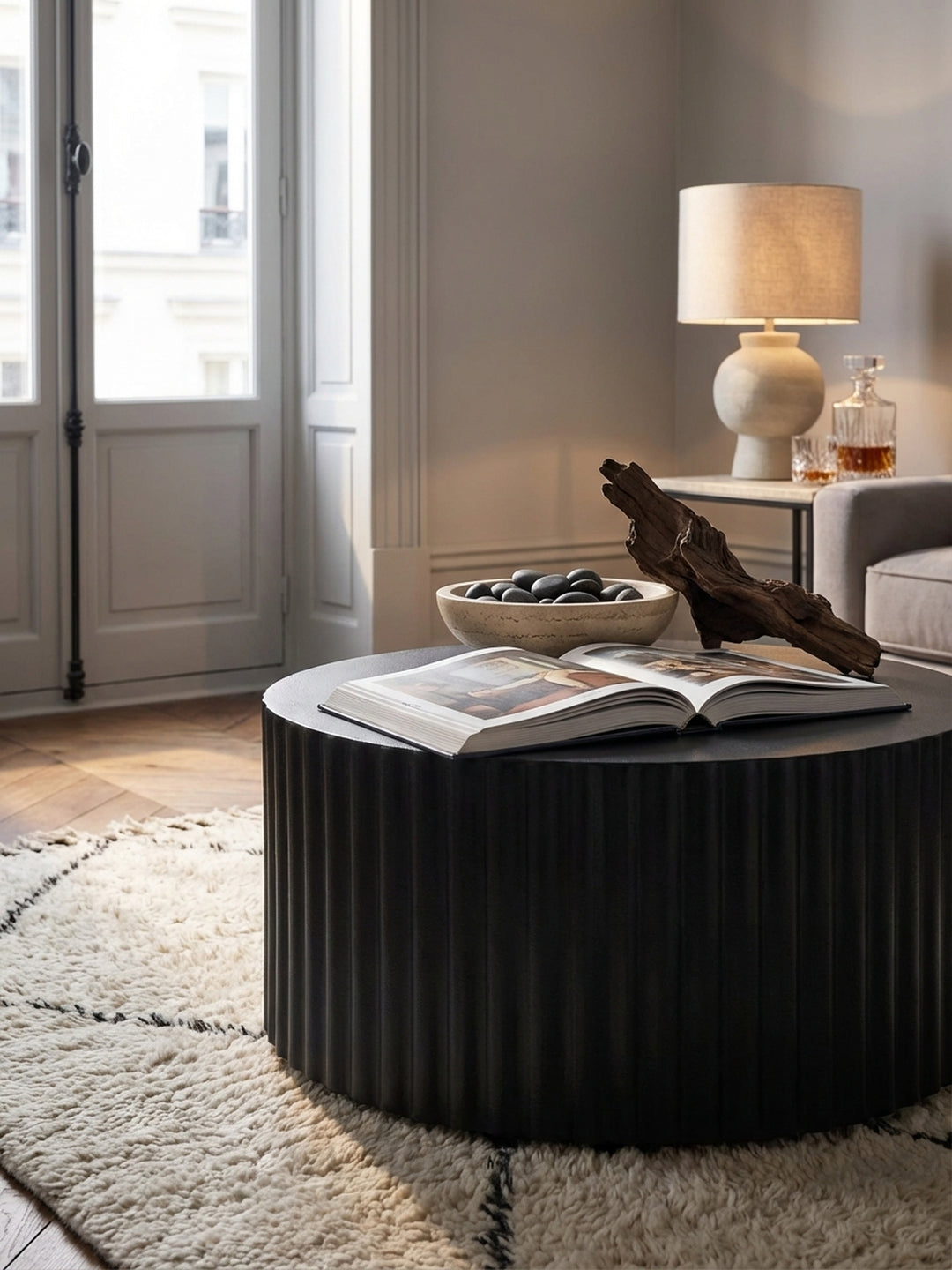 Ein handgefertigter Sofatisch aus Metall in Schwarz, dekoriert mit einem Kunstbuch und einer Vase mit Trockenblumen für ein gemütliches Ambiente._