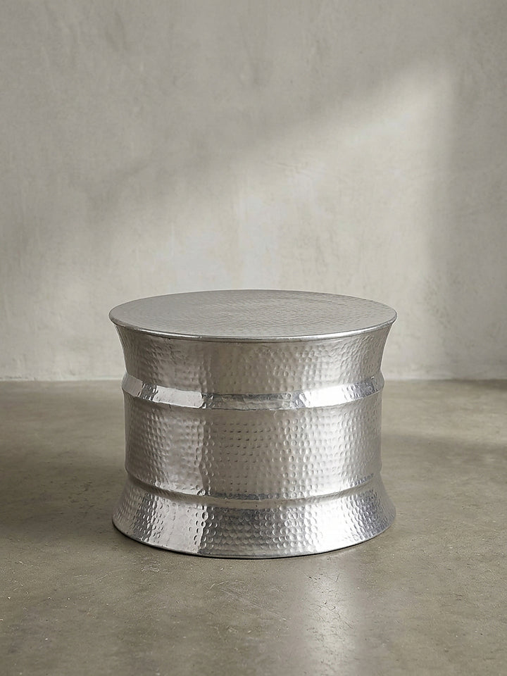 Runder Couchtisch aus komplett silberfarbenem Aluminium in der Frontansicht vor neutralem Hintergrund_
